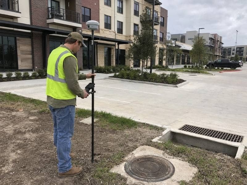 topographic survey crew mapping grades, pavement, and utilities for a high density site in College Station TX