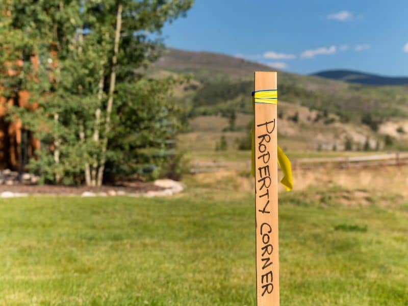 A survey flag marking one of the property line markers on a grassy lot